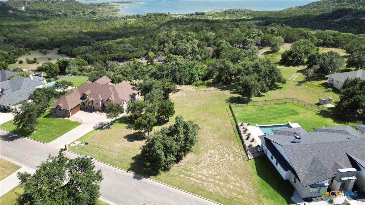 an aerial view of a house with a yard and lake view