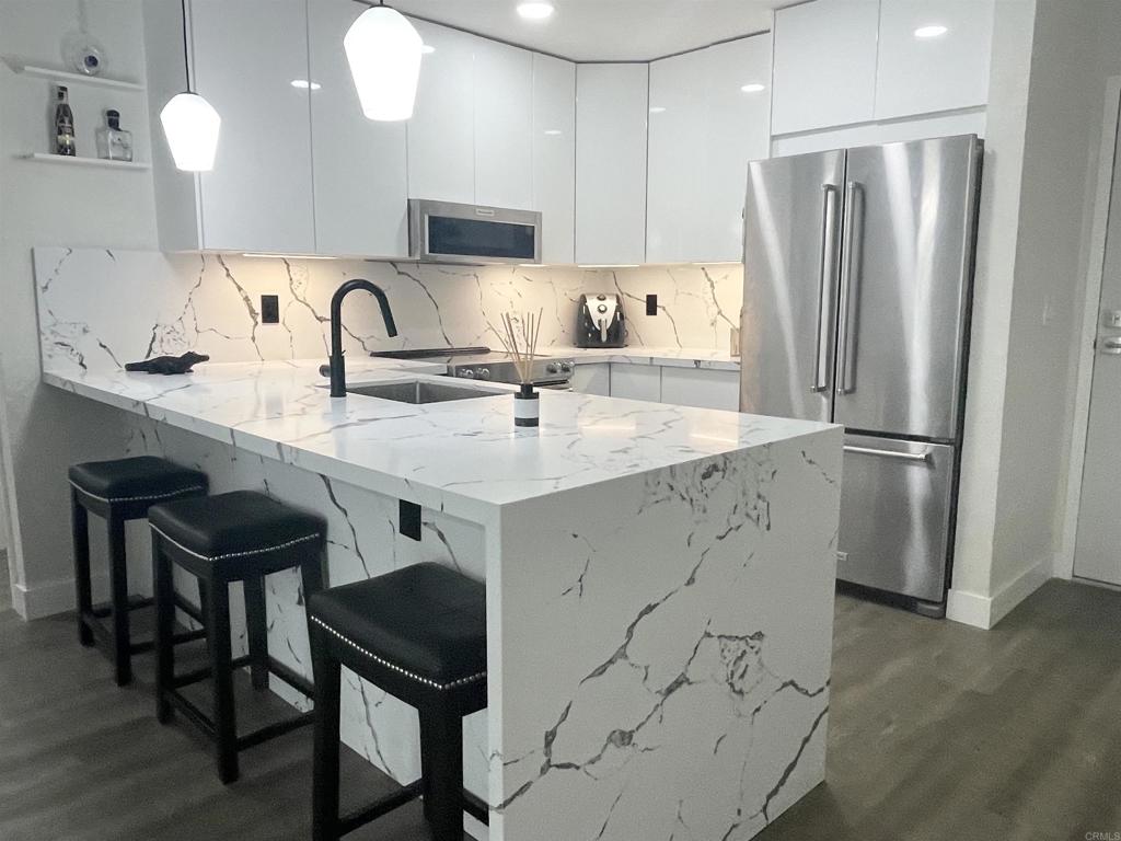 a kitchen with stainless steel appliances granite countertop a sink refrigerator and cabinets