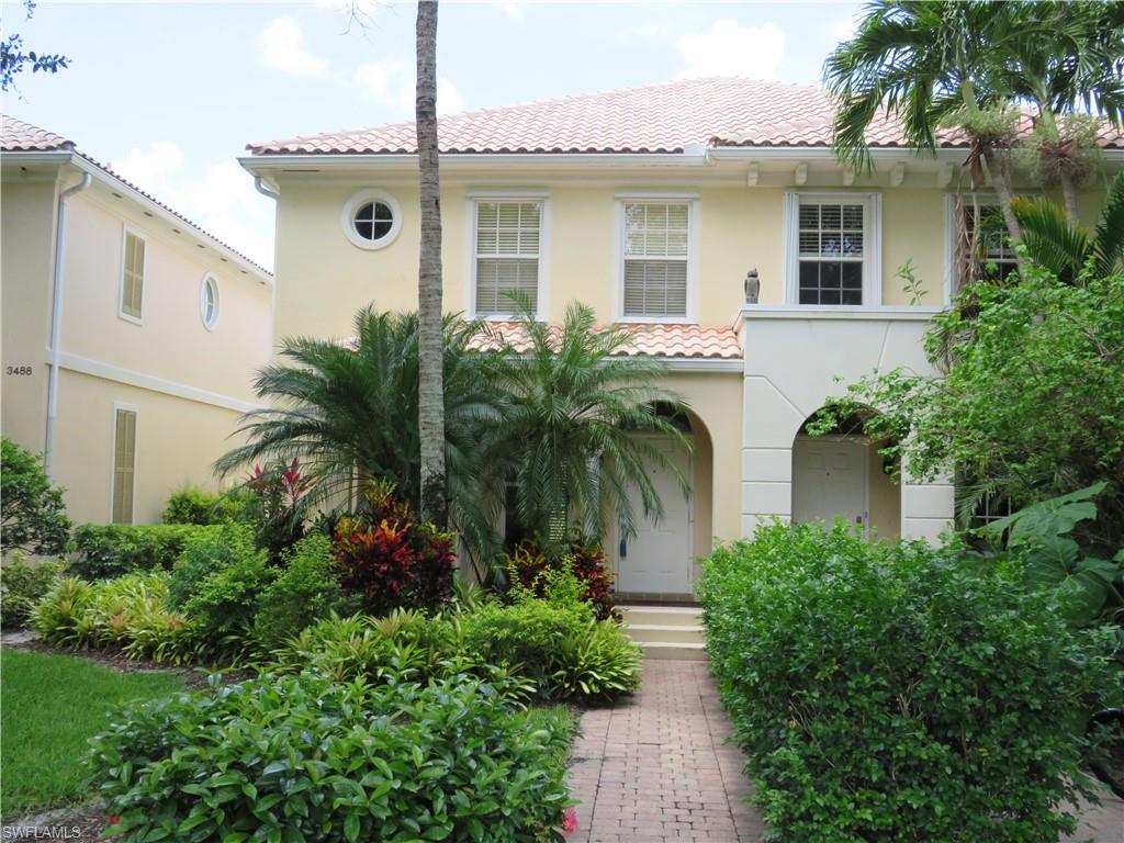 a front view of a house with plants