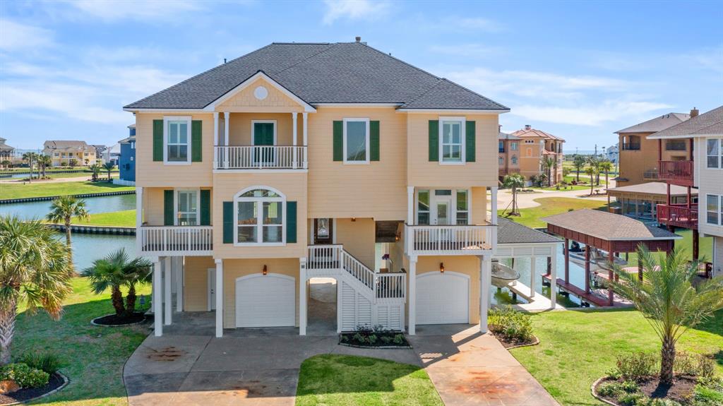 a front view of a house with a garden and lake view