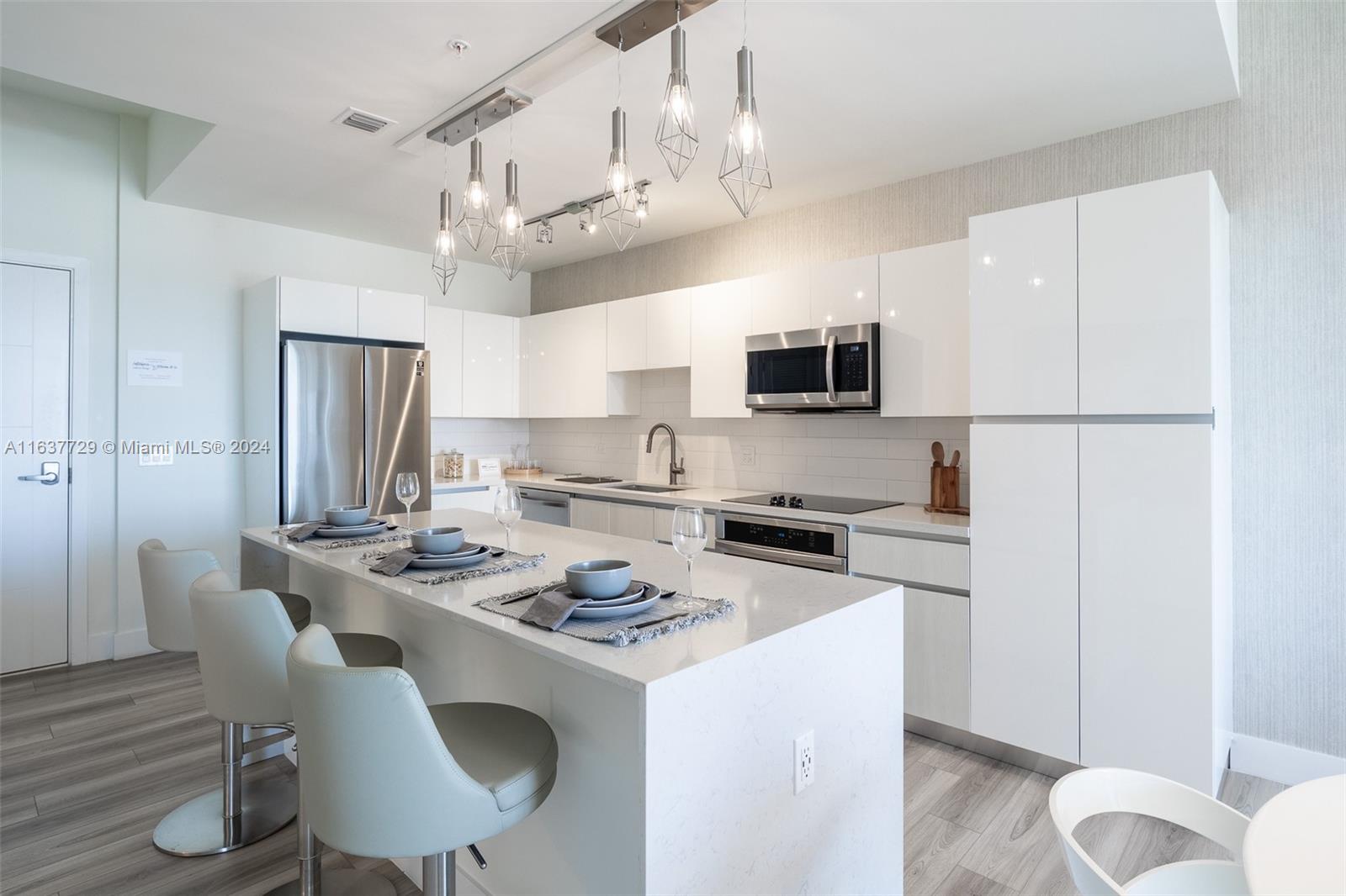 a kitchen that has a table chairs and a refrigerator