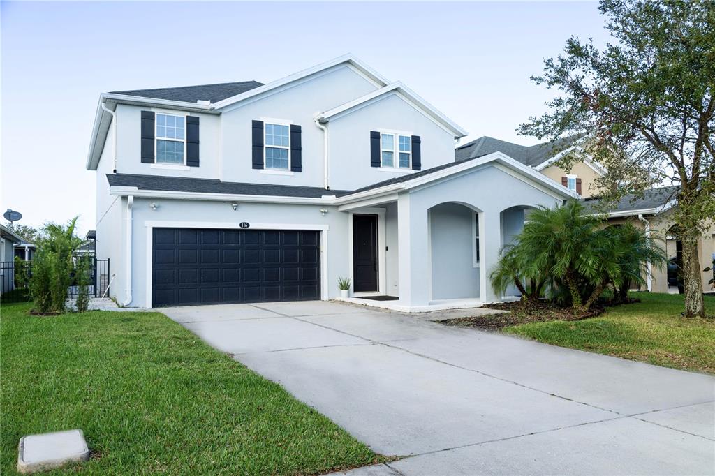 a front view of a house with a yard and garage