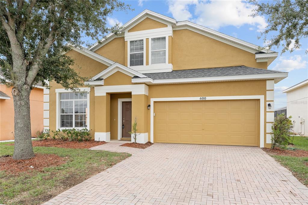 a front view of a house with a yard and garage