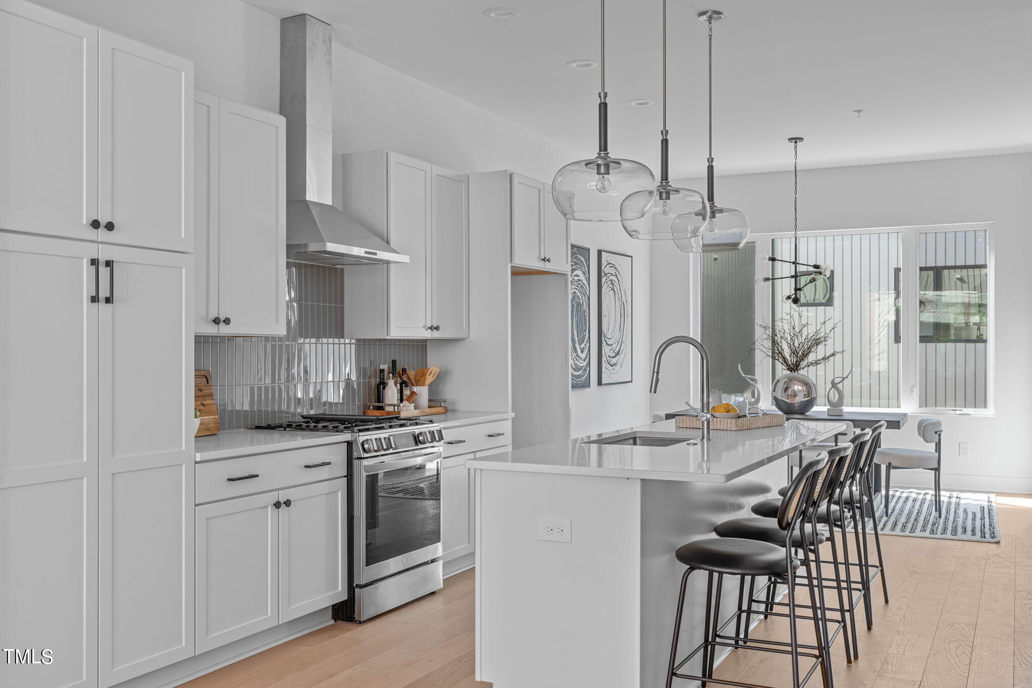 a large kitchen with white cabinets and stainless steel appliances