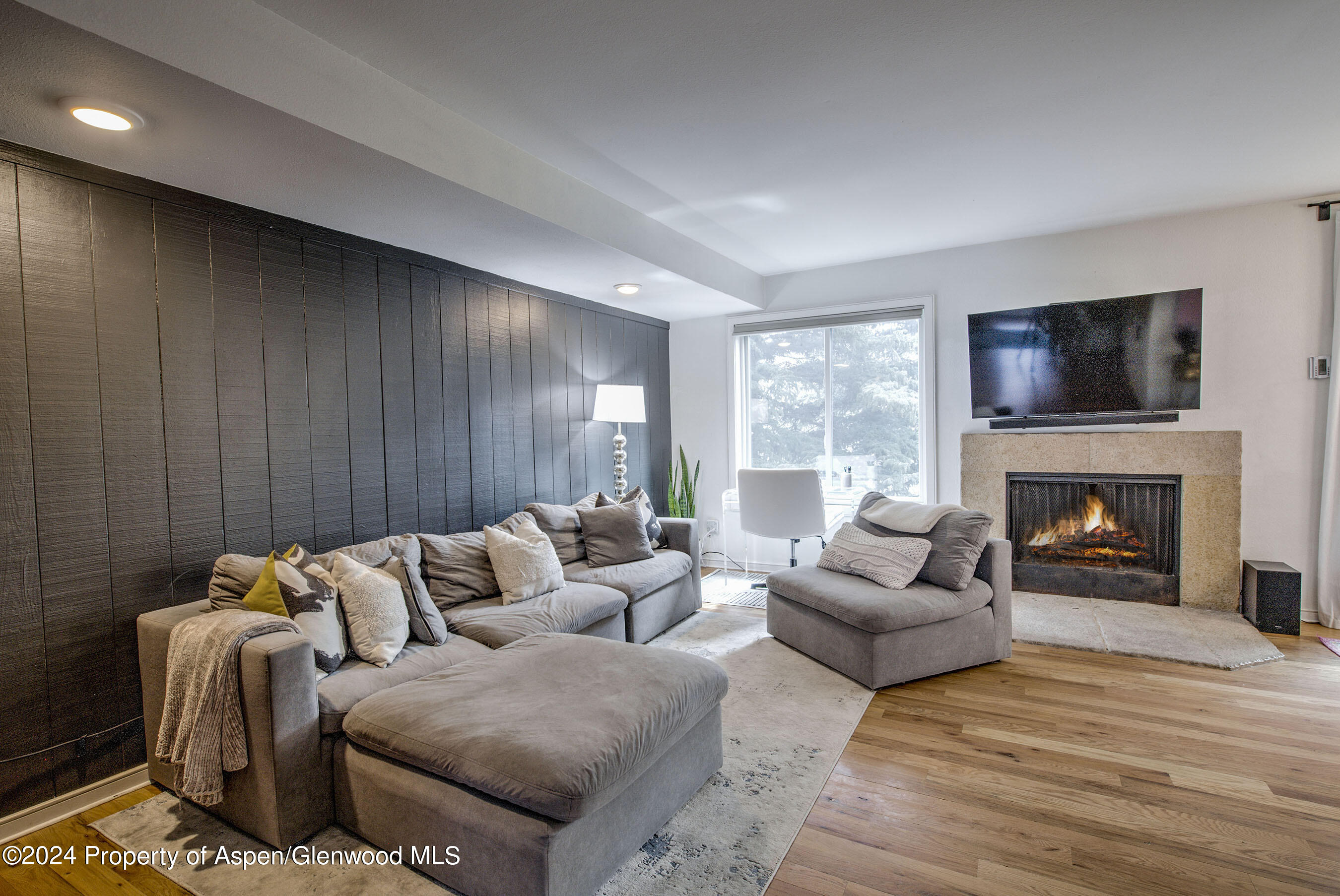 a living room with furniture a flat screen tv and a fireplace