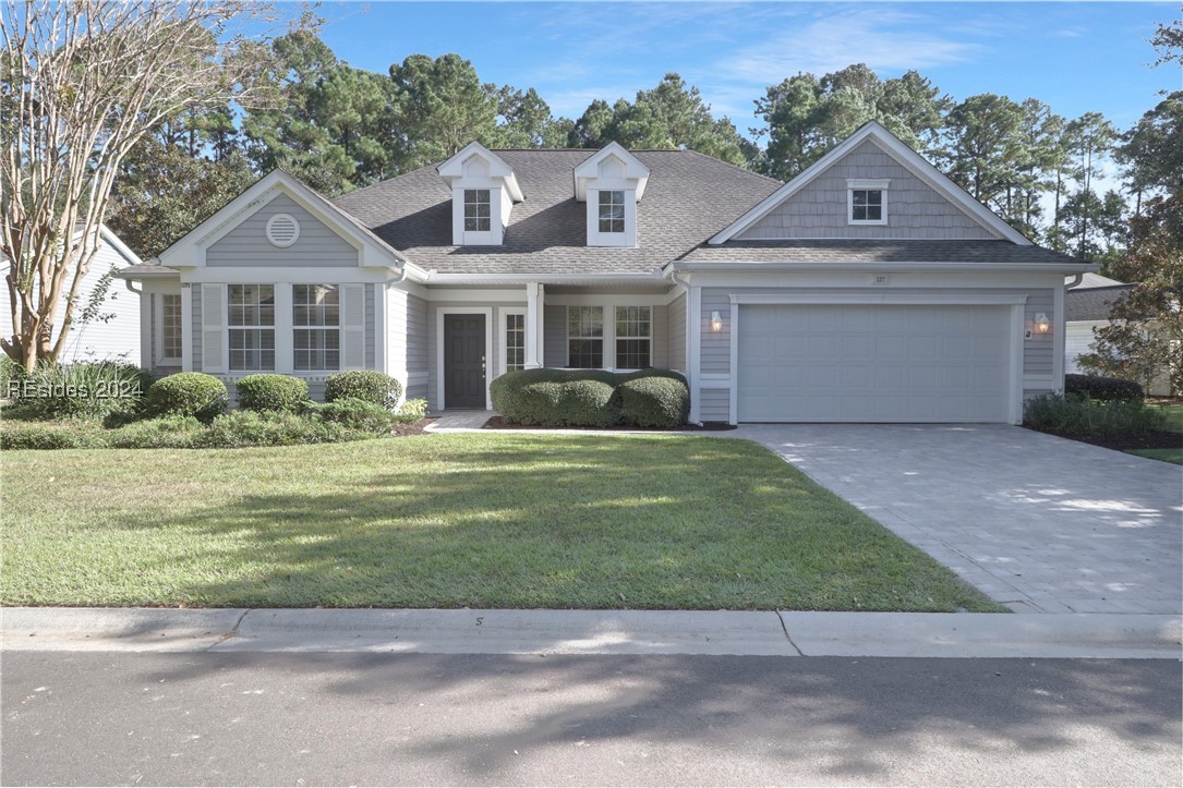 View of front of home with a front yard and a gara