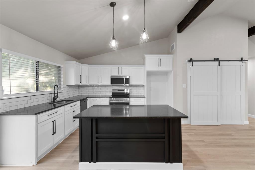 a kitchen with a sink stove and cabinets