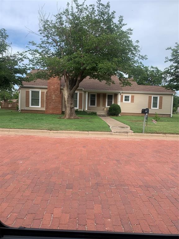 a front view of a house with a yard and trees