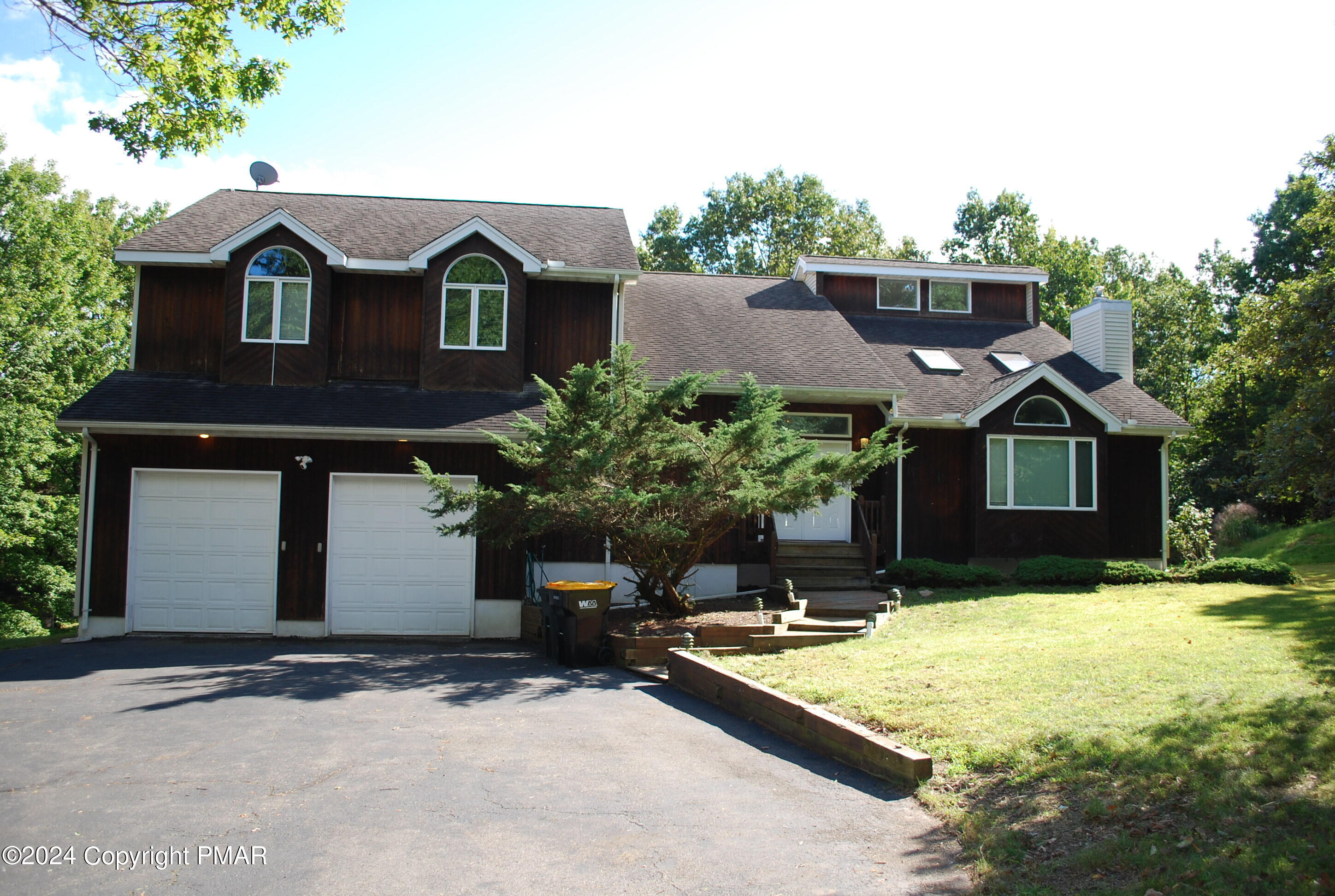 a front view of house with yard and trees in the background