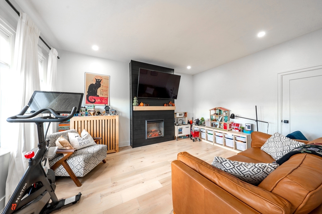 a living room with furniture a fireplace and a flat screen tv