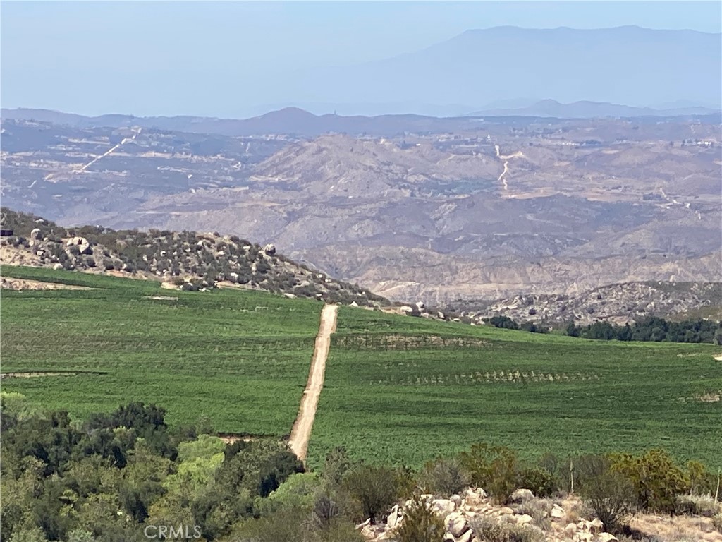 a view of a field with an ocean and a mountain in the background