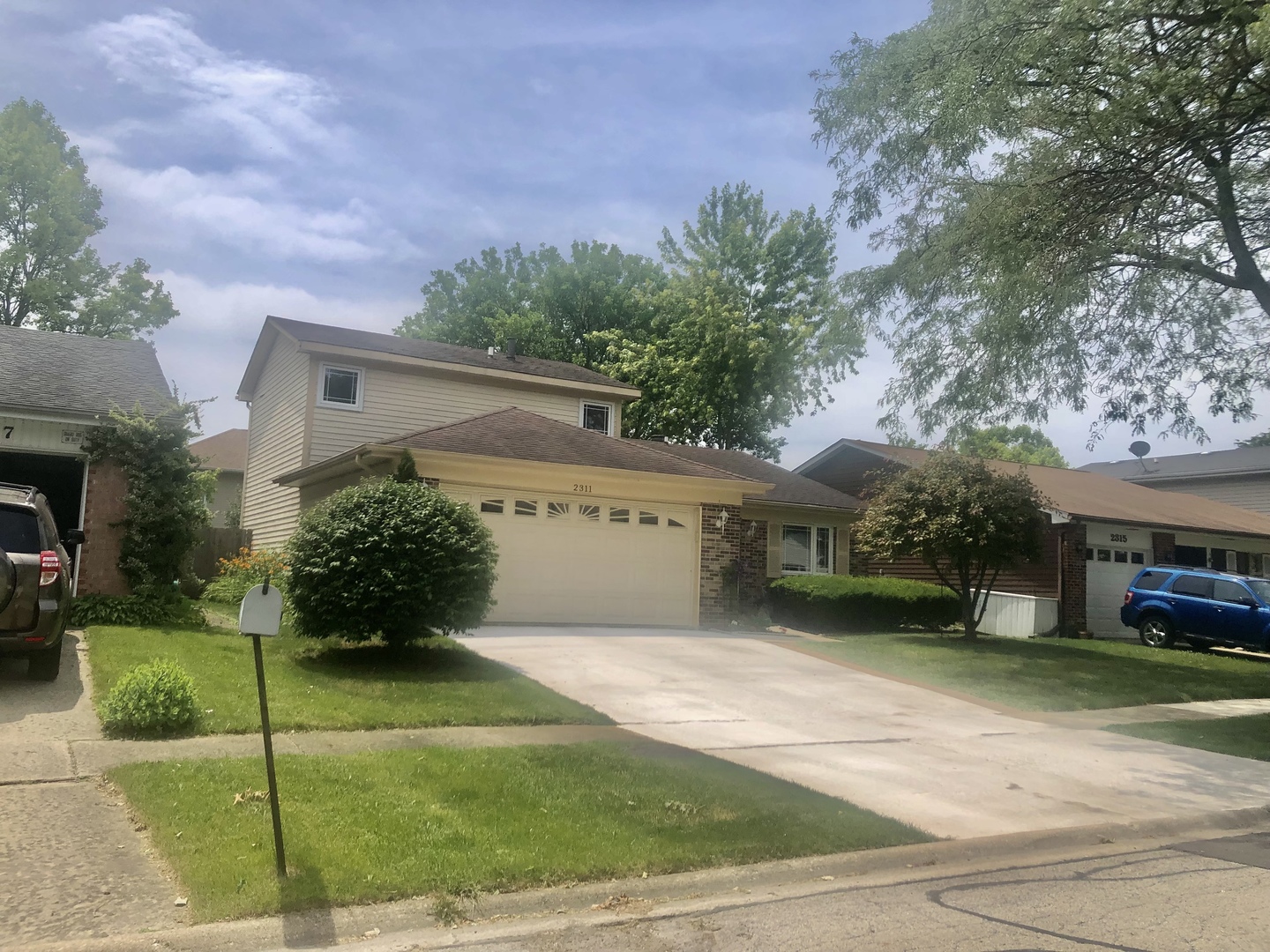 a view of a house with a yard and a garage