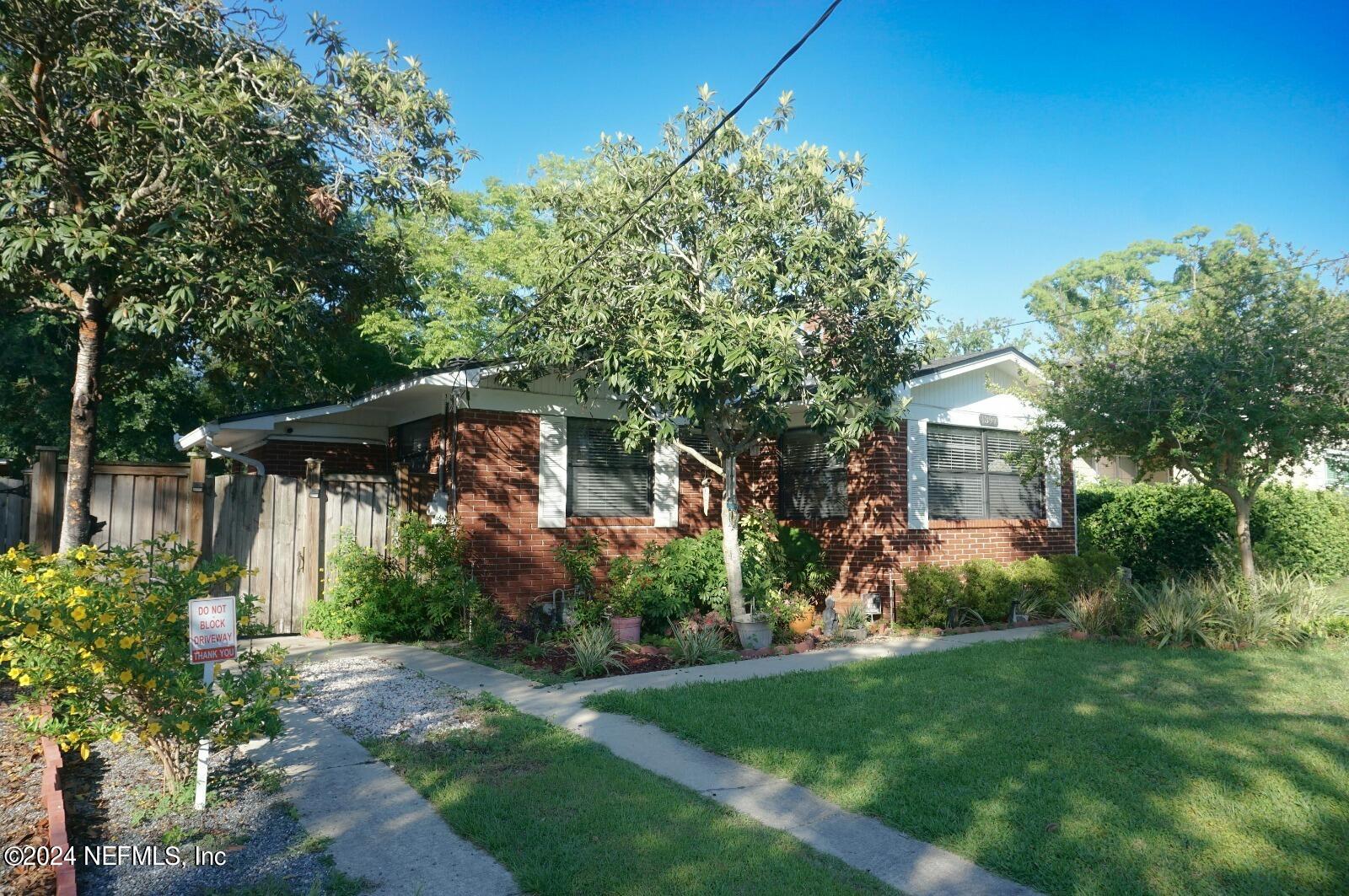 a backyard of a house with plants and tree