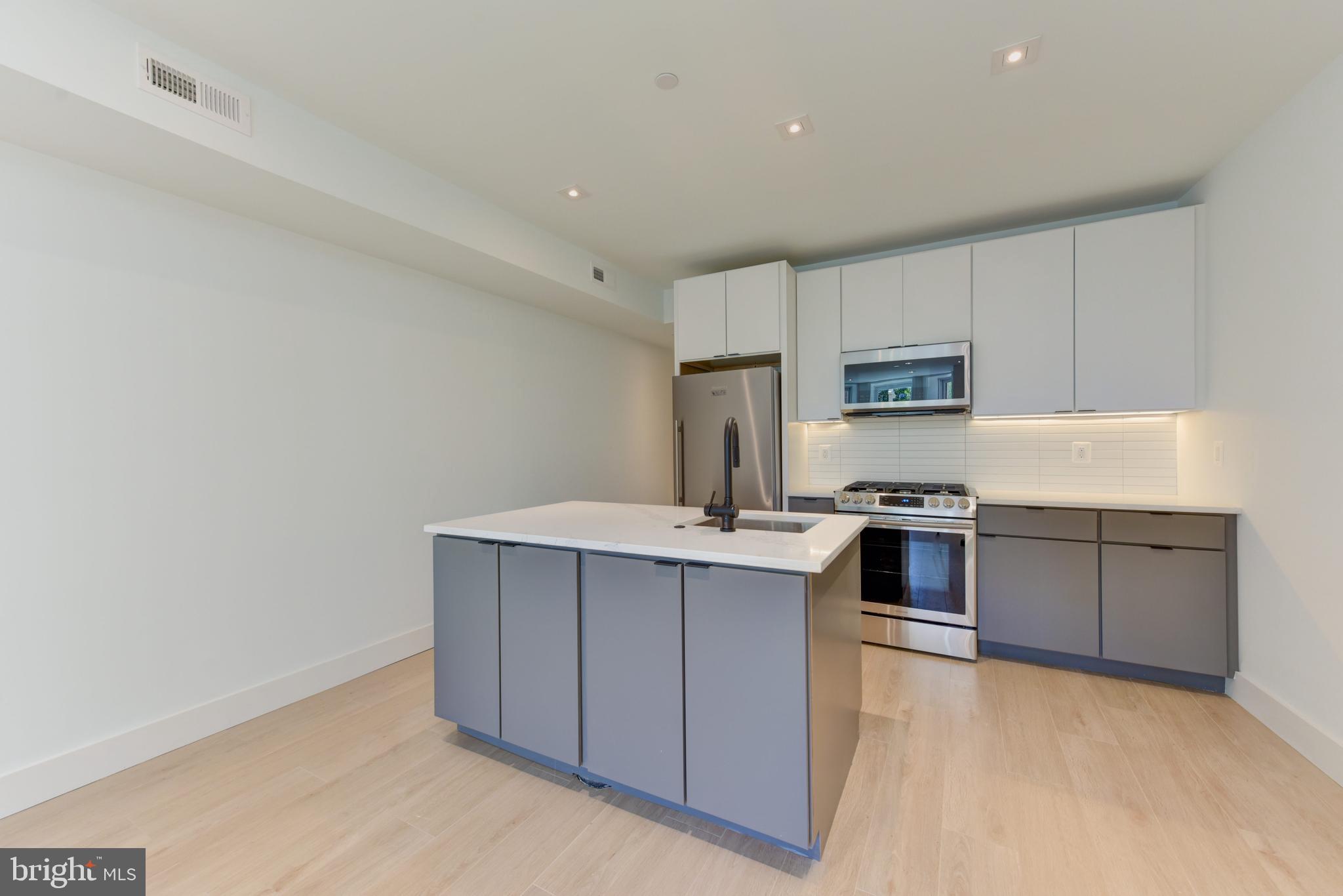 a kitchen with stainless steel appliances a sink stove and cabinets