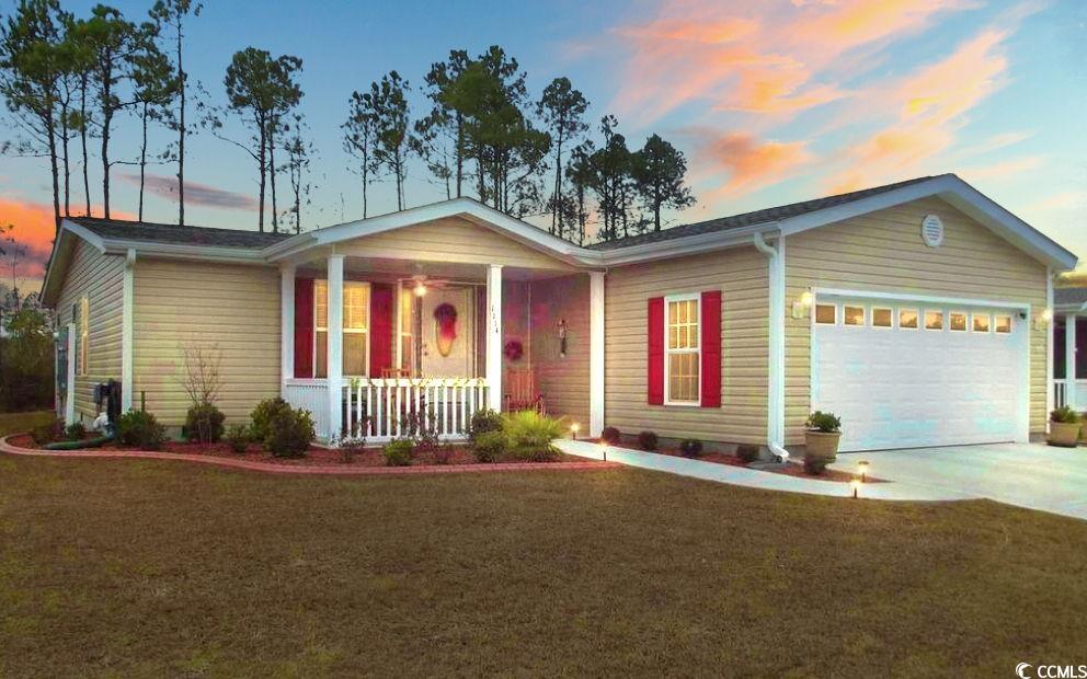 Single story home featuring a porch, a garage, and