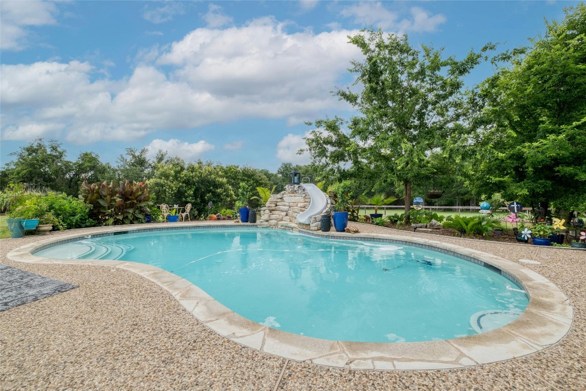 a view of a swimming pool with a yard and lake view in back