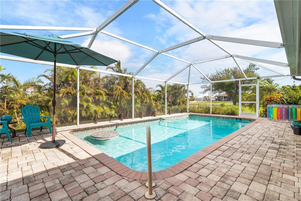 View of pool with a patio area and a lanai