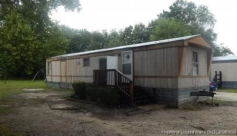 a side view of a house with backyard and garden