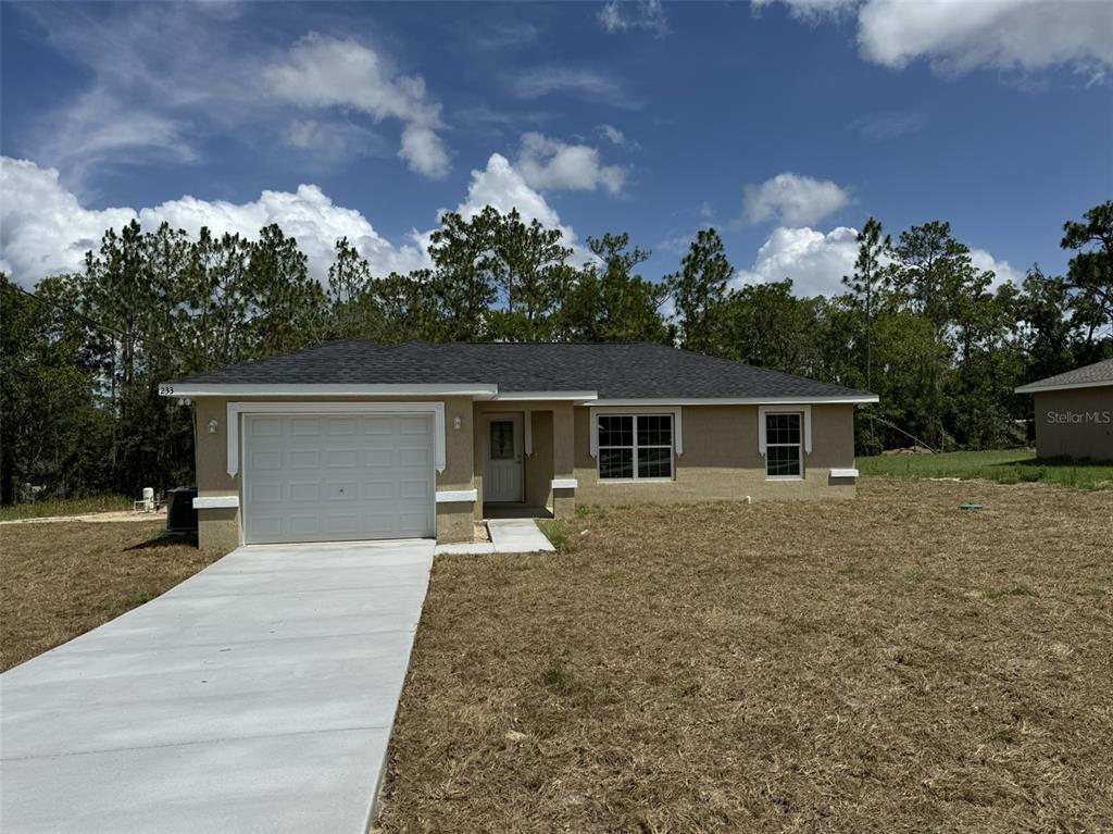 a front view of a house with a yard and trees