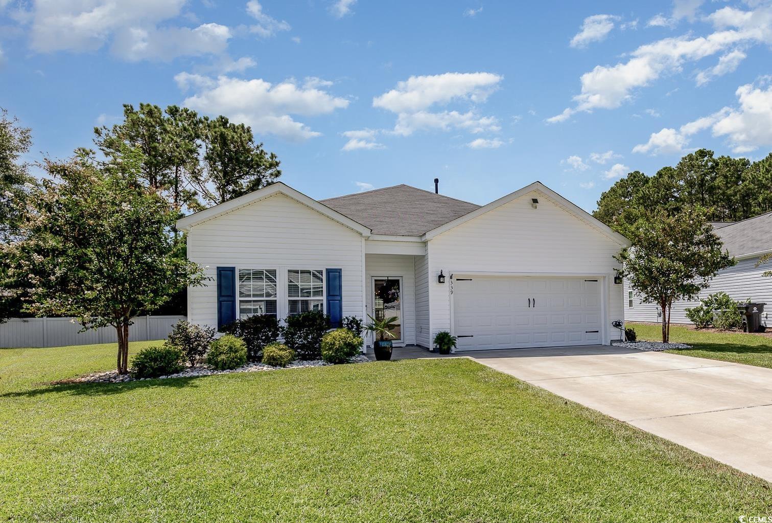 Ranch-style home featuring a front lawn and a gara