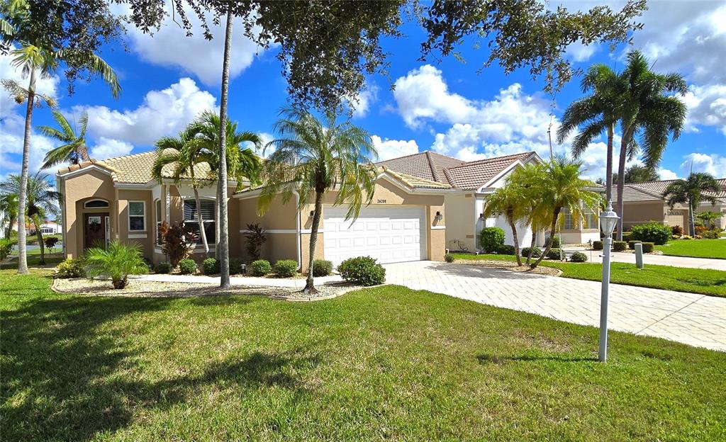 a view of a house with a yard and palm trees