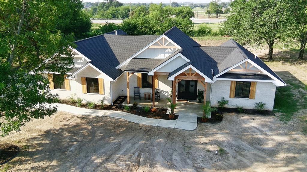 a front view of house with yard and trees in the background