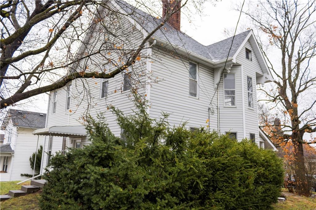 a view of a white house with a large tree