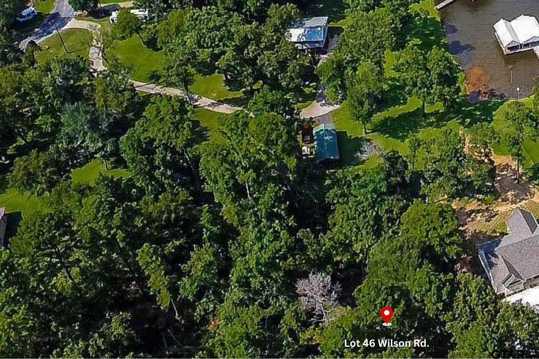 an aerial view of residential house with outdoor space and trees all around