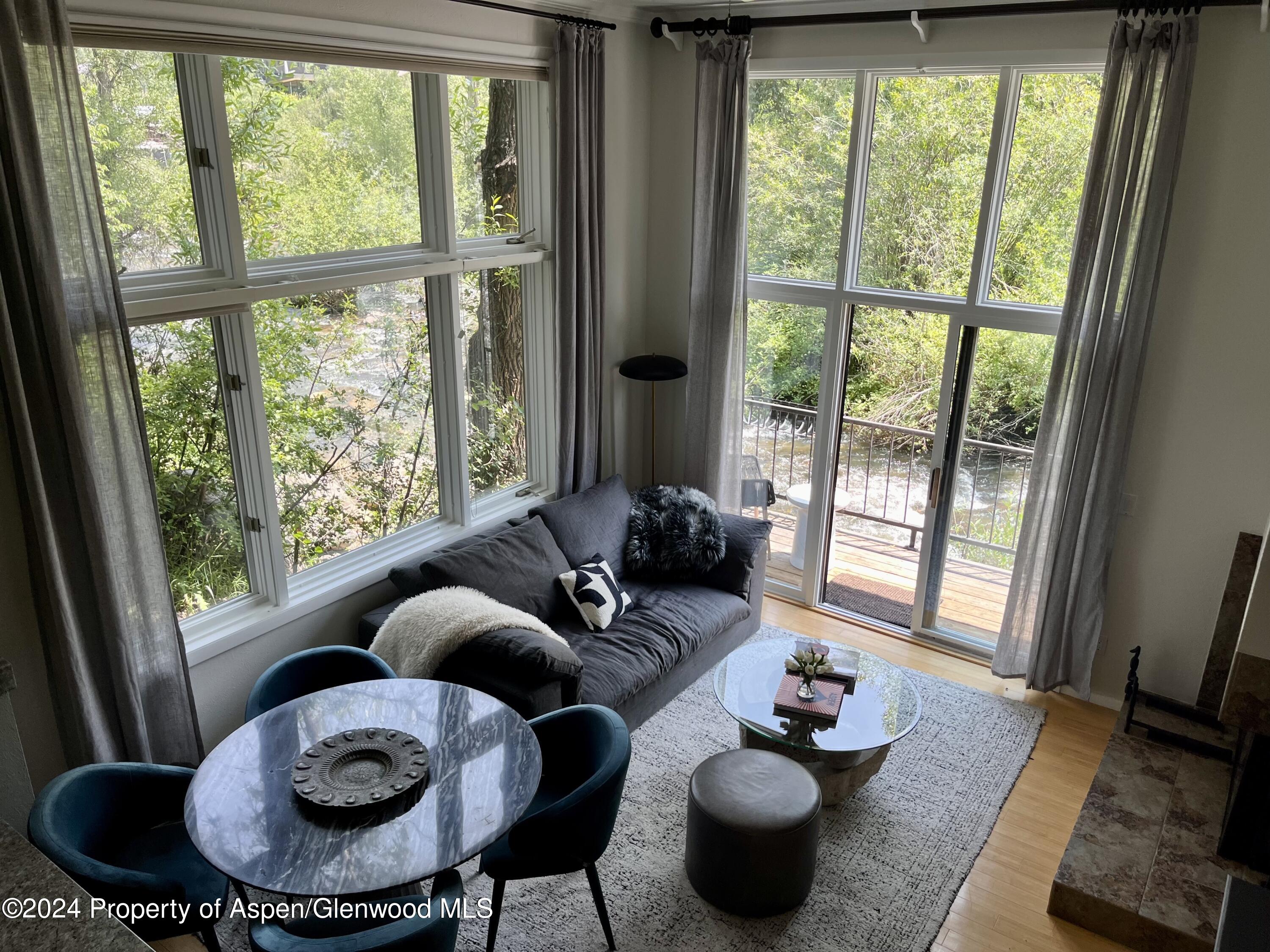 a living room with furniture and a floor to ceiling window