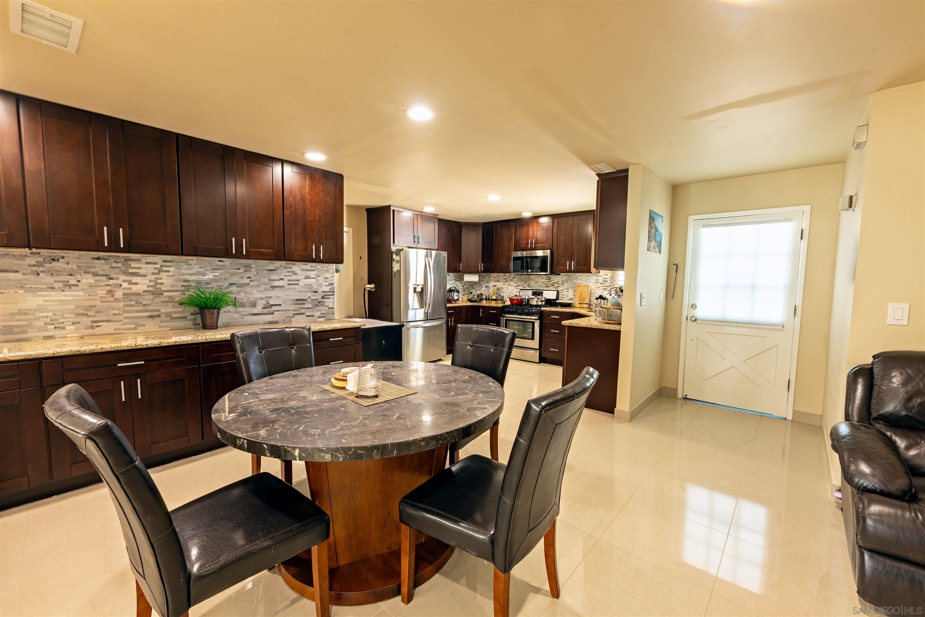 a kitchen with a dining table chairs and granite counter tops