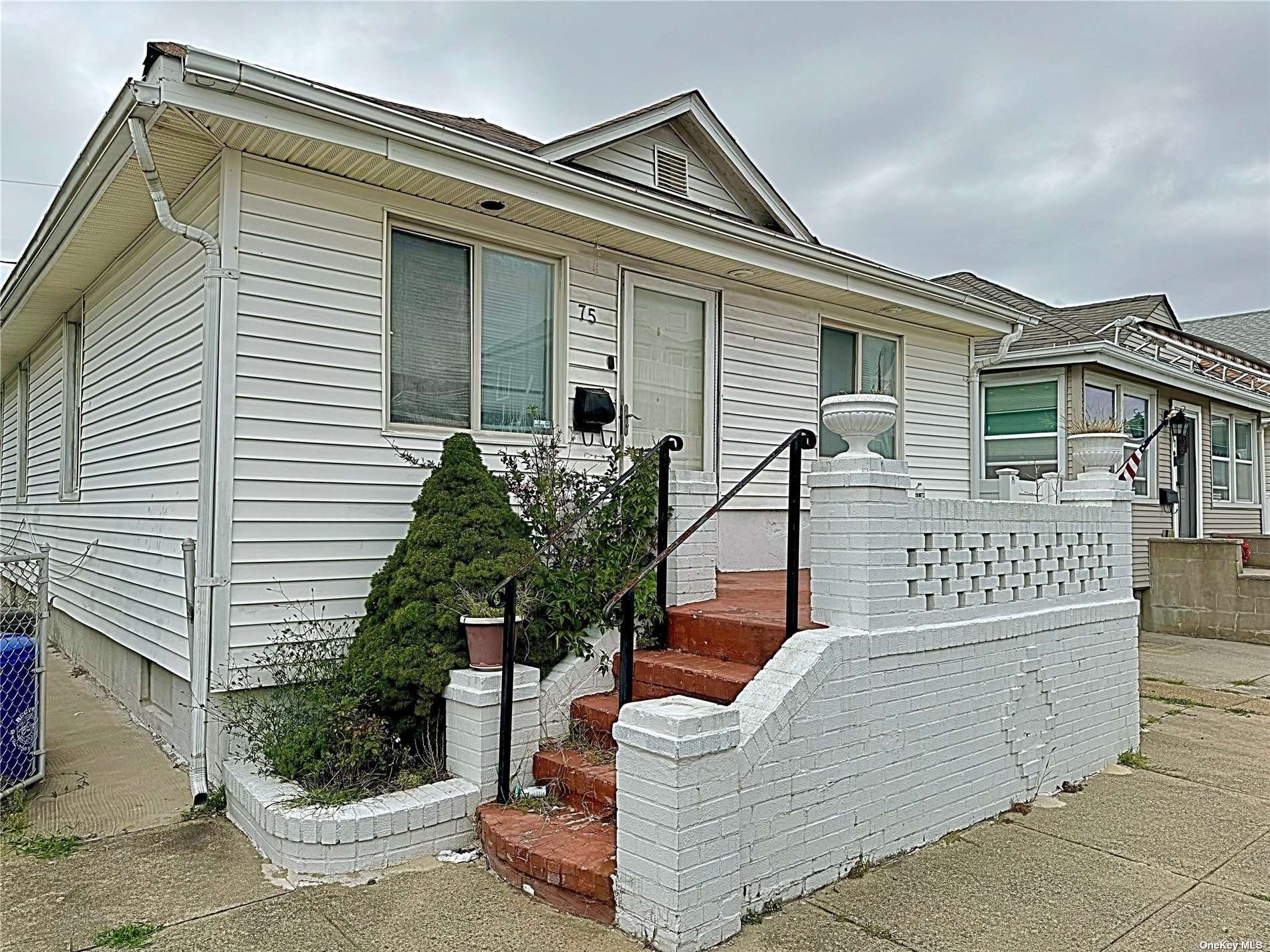 a front view of a house with plants