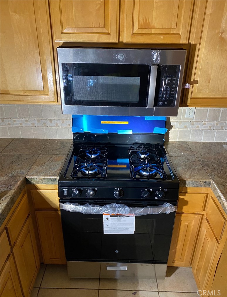 a stove top oven sitting inside of a kitchen