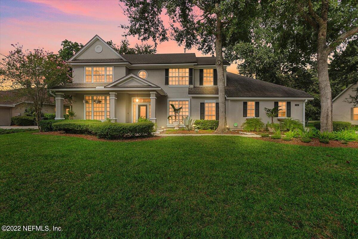 a front view of a house with a yard and trees