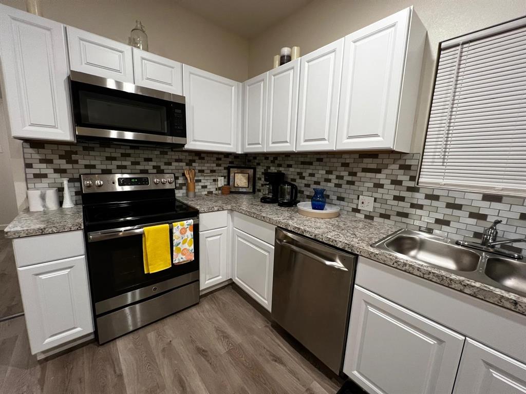 a kitchen with granite countertop a sink and a stove top oven