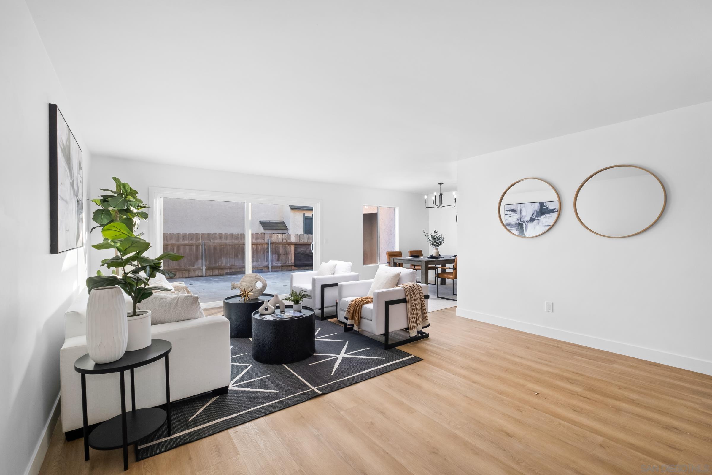 a living room with furniture a large window and potted plants