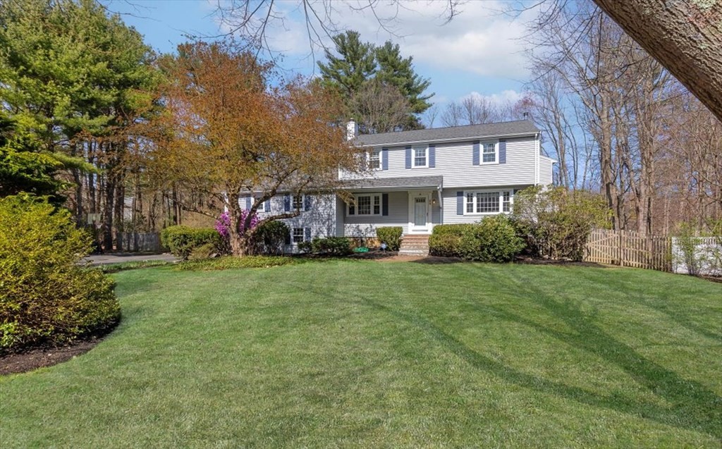 a view of a house with a big yard and large trees