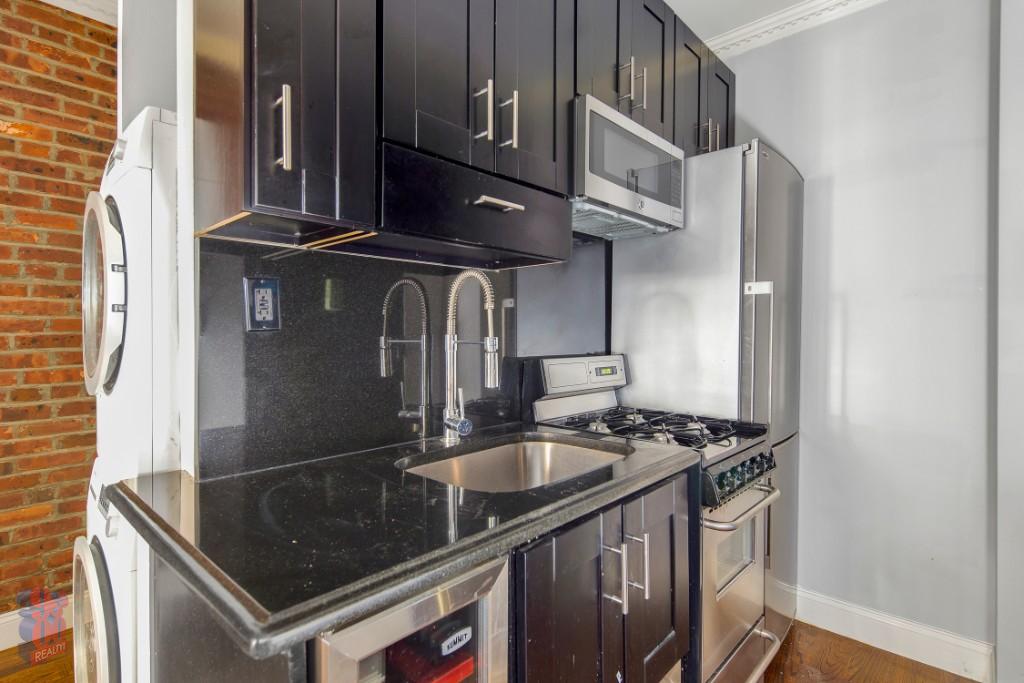 a kitchen with stainless steel appliances granite countertop a sink stove and cabinets