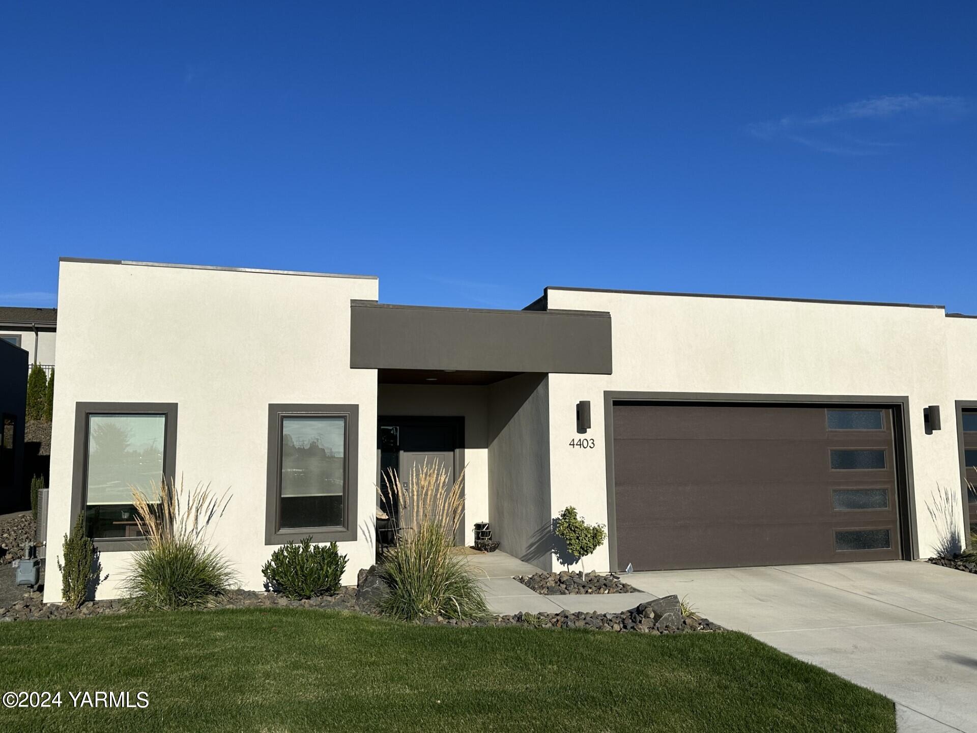 a front view of a house with a yard and a garage