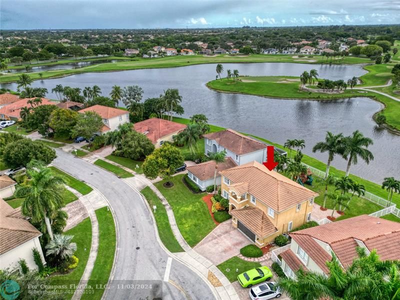 an aerial view of a house with a garden and lake view