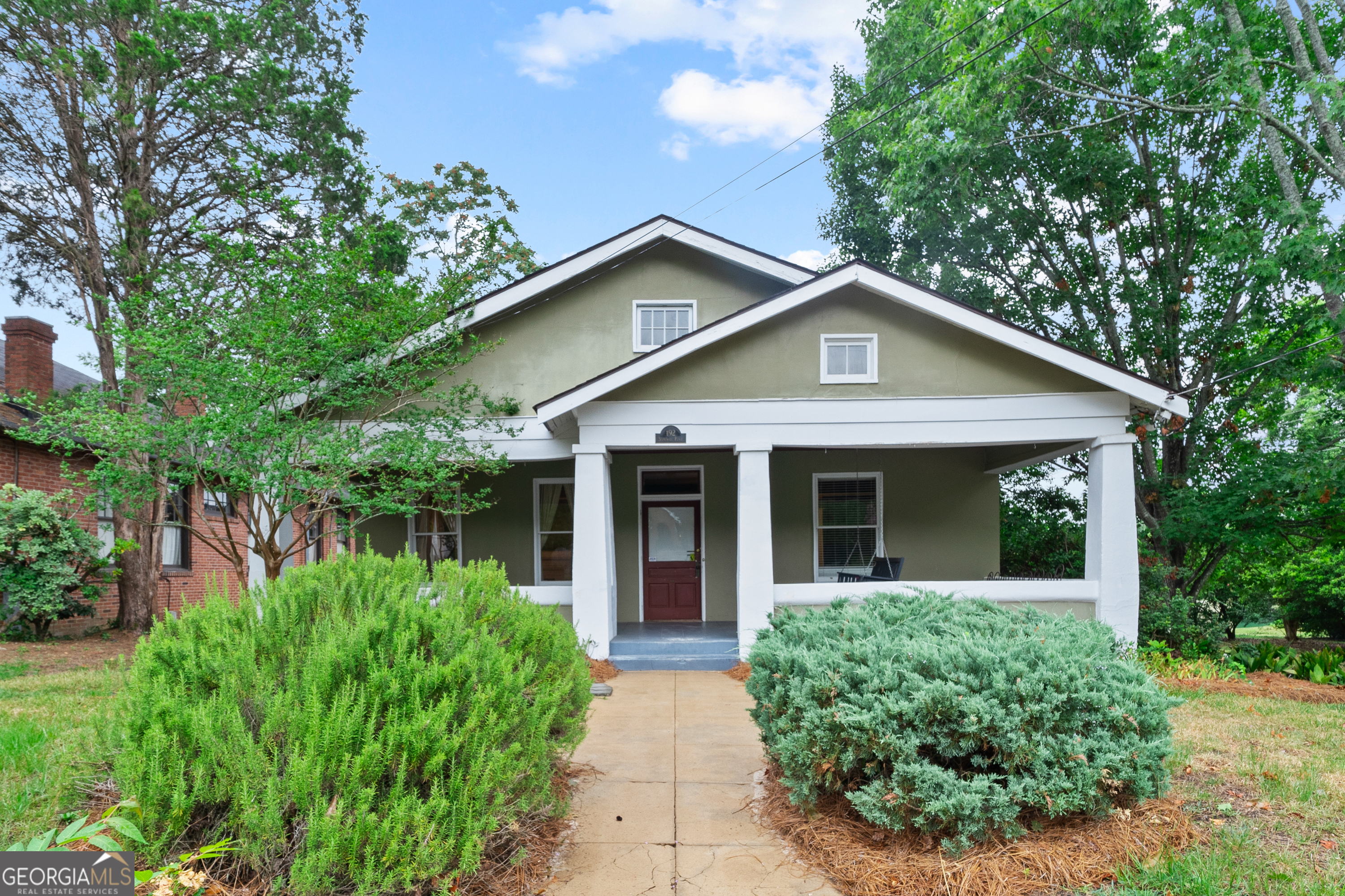 a front view of a house with yard and green space