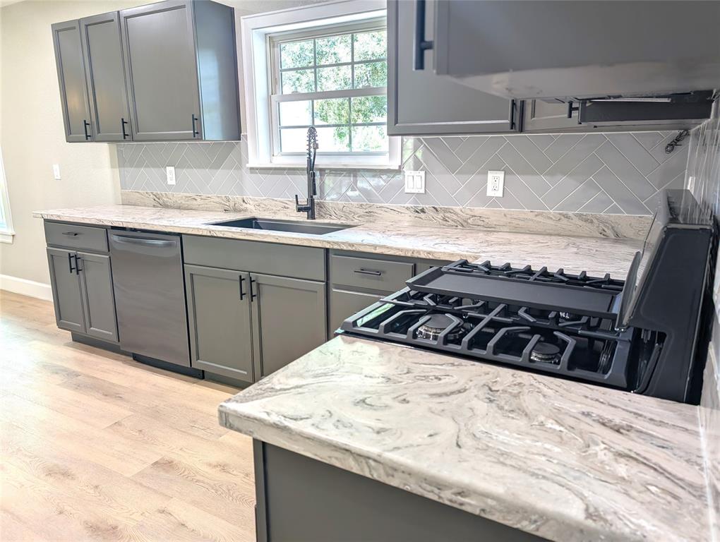 a kitchen with a sink stove and cabinets