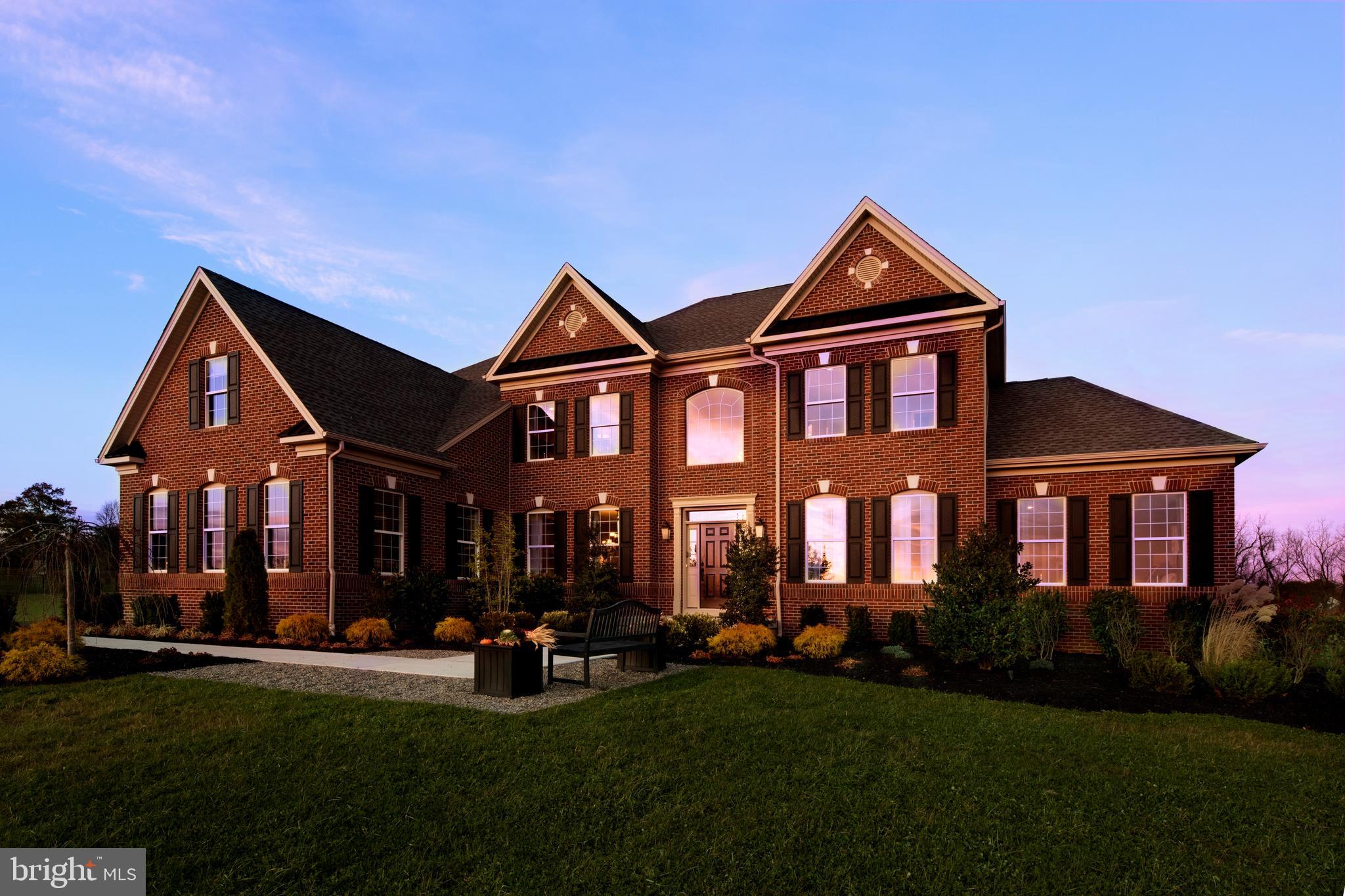 a front view of a house with a yard and trees