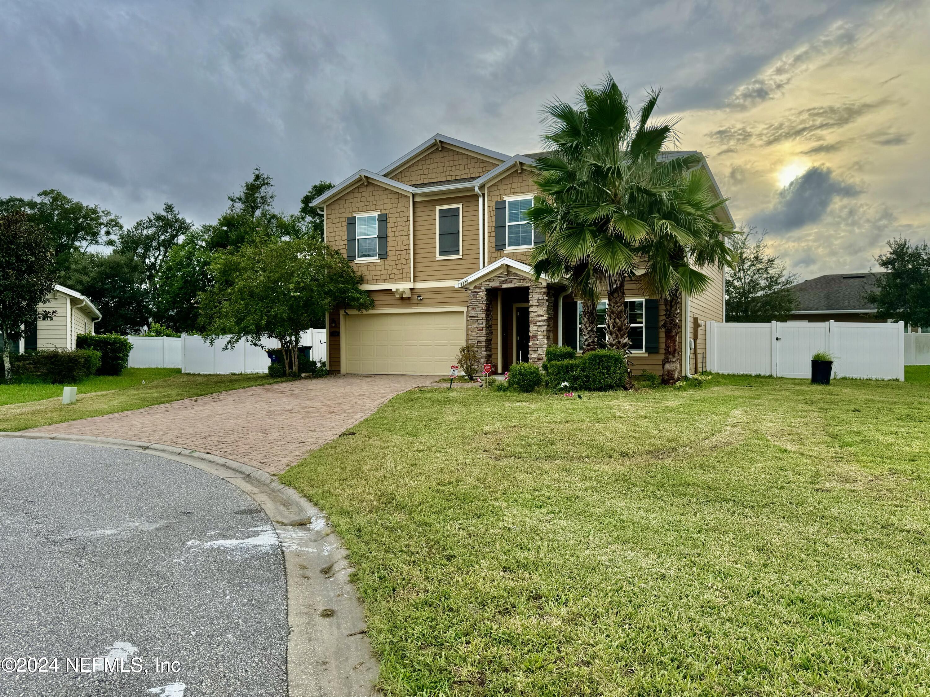 a front view of a house with a yard and trees