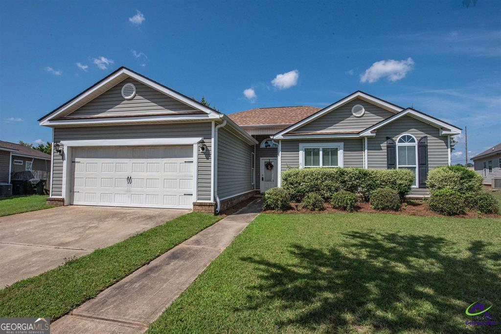 a front view of a house with a yard and garage