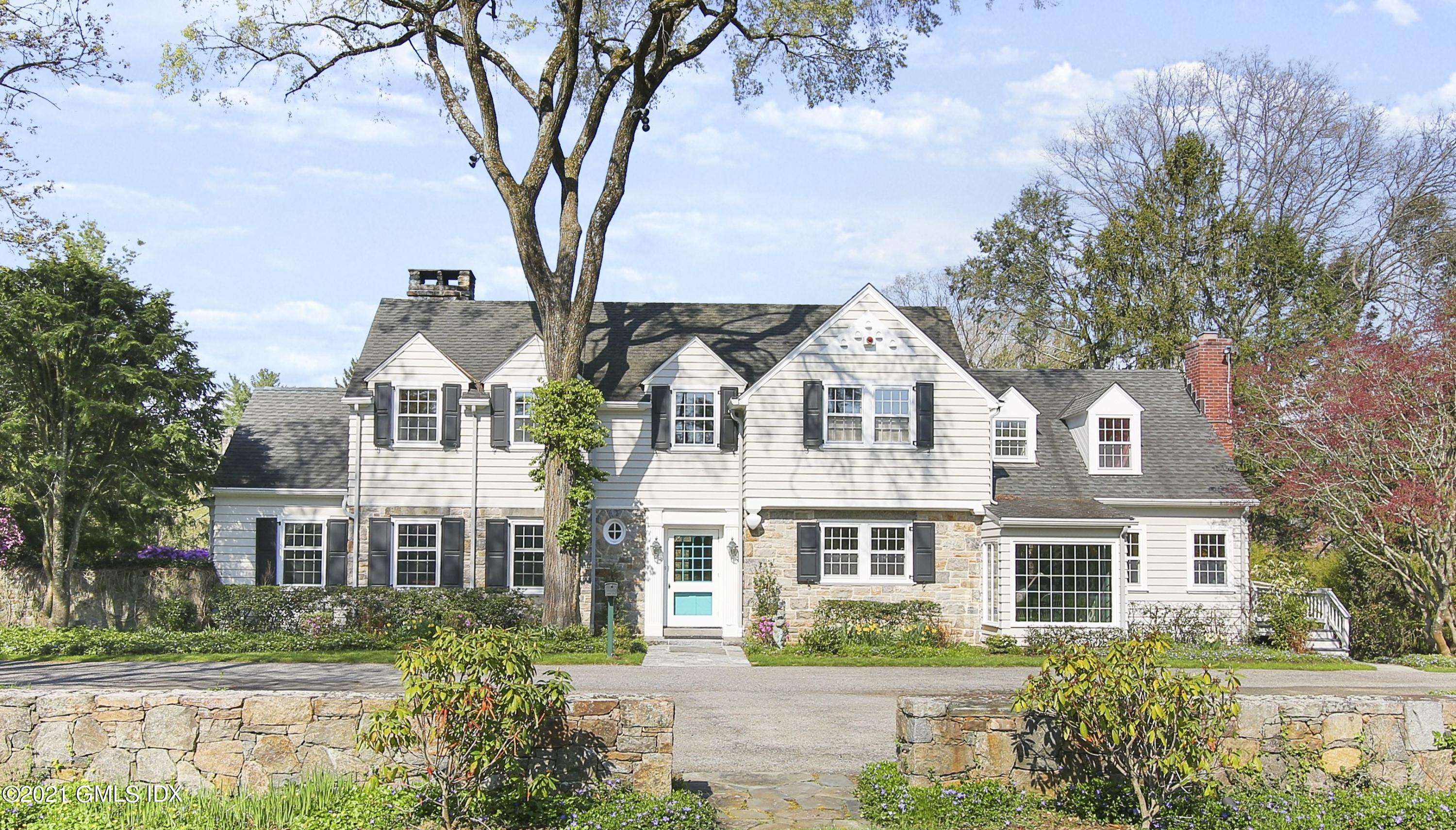 a front view of a residential houses with yard and green space