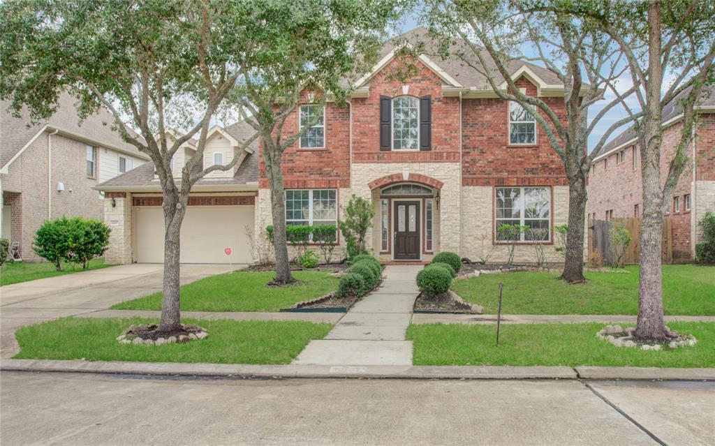 a front view of a house with a yard and trees