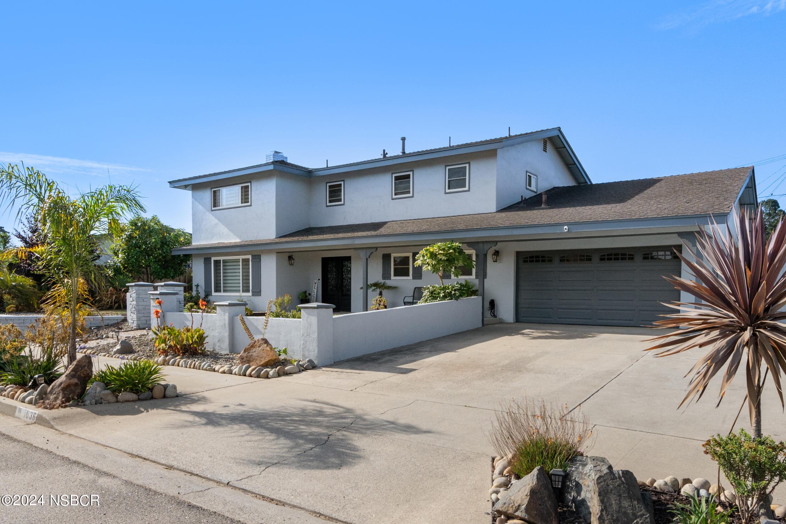 a front view of a house with garden