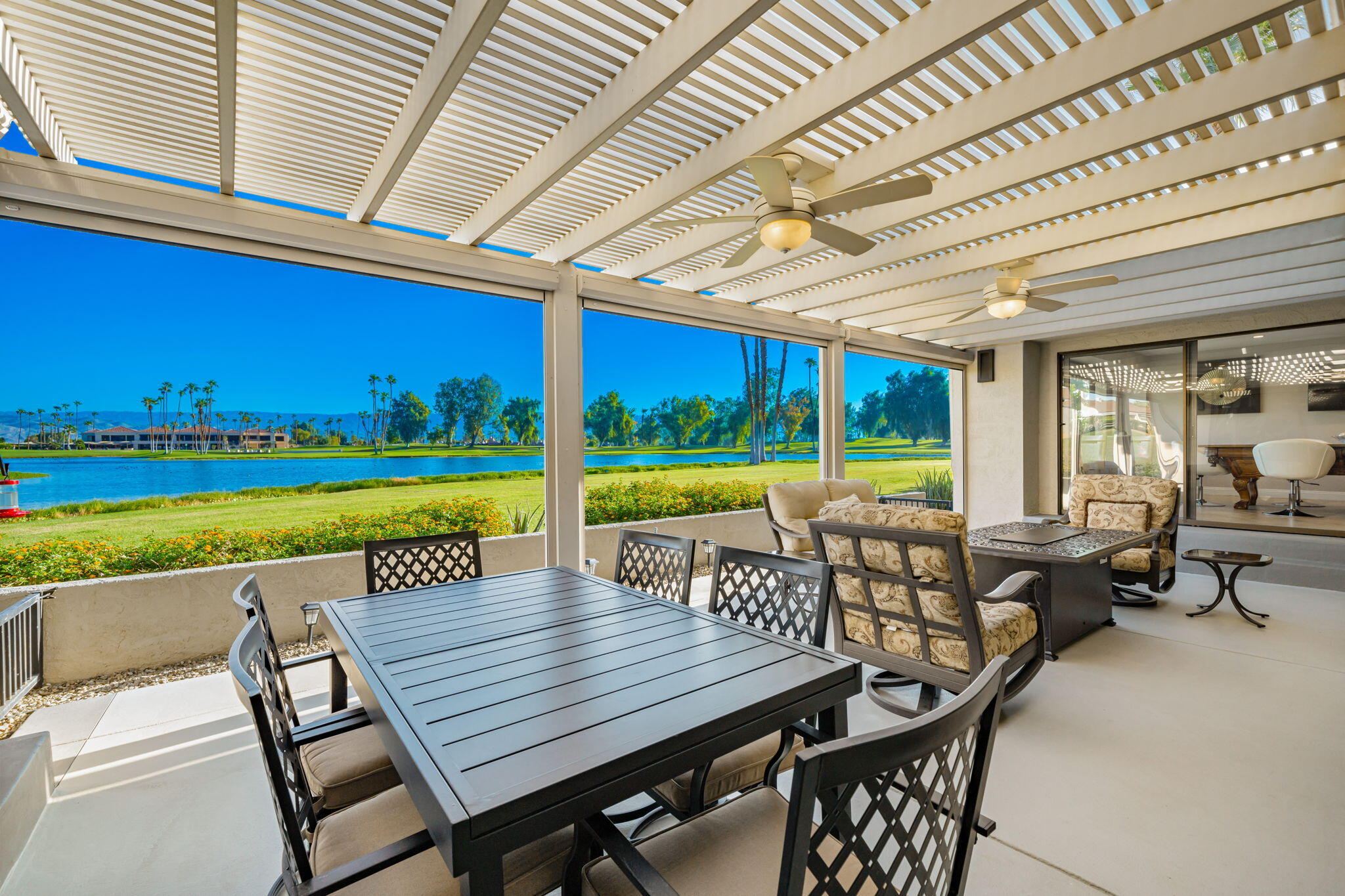 a view of a patio with a table chairs and a backyard