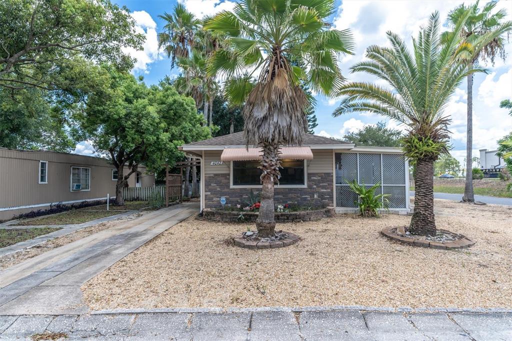 a front view of a house with garden yard and tree