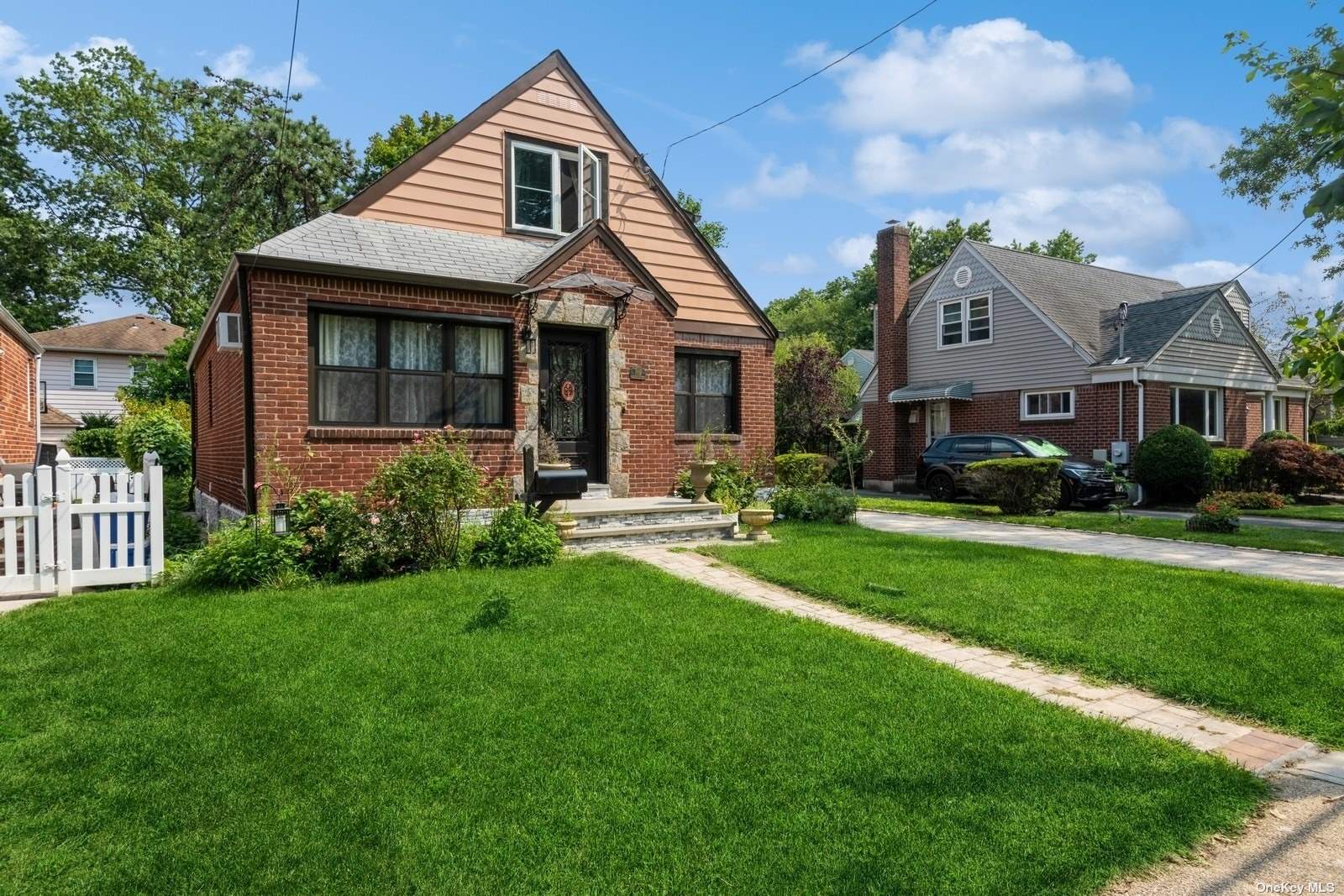 a front view of a house with a yard and trees